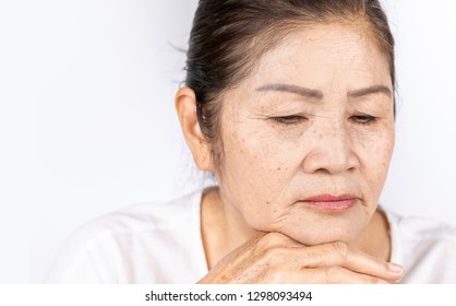 Elderly Asian Woman Portrait 60-70 Years Old With Black Hair And Hazel Eyes Looking Serious Thinking Isolated On White Background With Copy Space