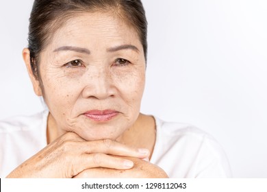 elderly asian woman portrait 60-70 years old with black hair and hazel eyes looking serious thinking isolated on white background with copy space