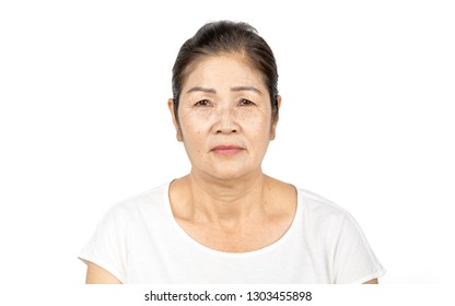 Elderly Asian Woman Portrait 60-70 Years Old No Make Up With White Clothes Black Hair And Hazel Eyes Isolated On White Background