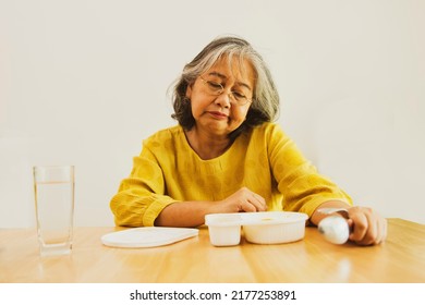 Elderly Asian Woman Sitting Down To Eat A Boring Lunch Box, Tasteless, No Nutrients, No Appetite, Does Not Like To Eat : Unhealthy Food And Foods That Are High In Fat And High In Cholesterol Concept.