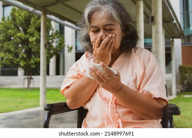 Elderly Asian Woman Sitting Wheelchair And Hospital Patient Suffering From Pneumonia And Coughing At Risk Of Lung Cancer Is Shocked To See Bloody Sputum : Old Woman Was Shocked See The Bloody Sputum.