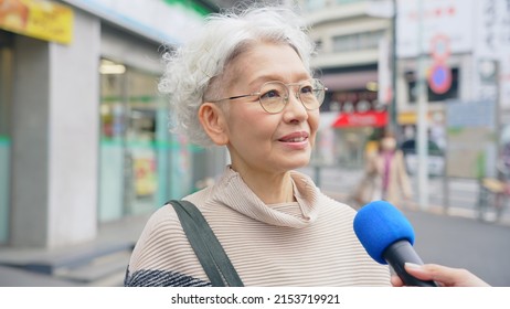 Elderly Asian Woman Taking Street Interview. TV Reporting.