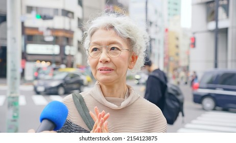 Elderly Asian Woman Taking Street Interview. TV Reporting.