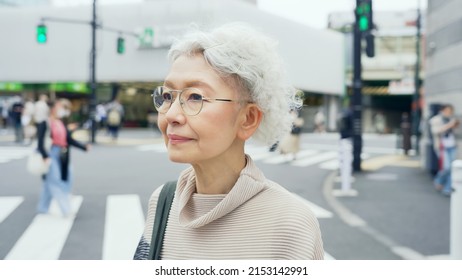 Elderly Asian Woman Walking In The Town.