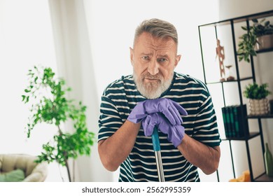 Elderly bearded man in casual t-shirt relaxing at home in sunny living room, enjoying natural daylight and leisure time - Powered by Shutterstock