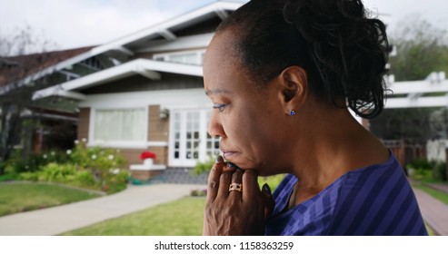 An Elderly Black Woman Prays Outside Her Home