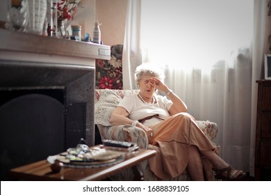 
elderly bored lady in the armchair at home