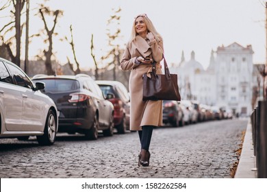 Elderly Business Woman With Phone Walking Down The Street