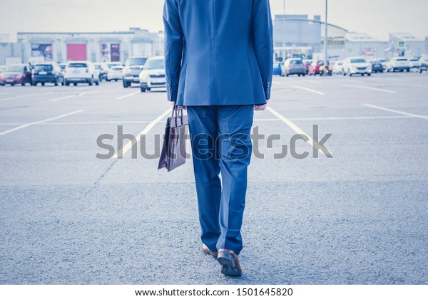 Elderly\
Businessman in blue suit and brown briefcase on the outdoor car\
parking . Dramatic. post-processing.\
Concept