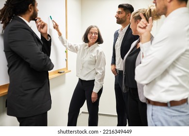 Elderly Businesswoman Presenting A Presentation On The Whiteboard In The Conference Room