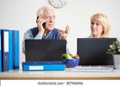 Elderly Busy Man Transacting Business Cases On The Phone