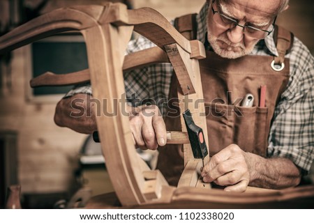 elderly carpenter builds a classic style chair