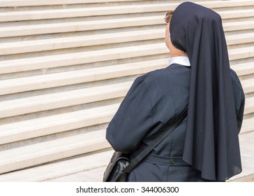 An Elderly Catholic Nun Facing High White Marble Stairs