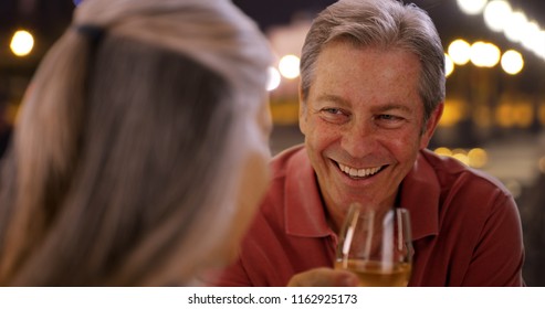 Elderly Caucasian couple have conversation over wine at restaurant  - Powered by Shutterstock