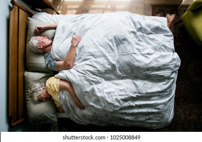 Elderly Caucasian Couple Sleeping On The Bed