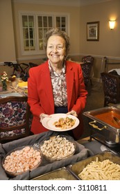 Elderly Caucasian Woman At Buffet In The Dining Room Of A Retirement Community Center.