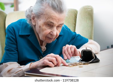 Elderly Caucasian Woman Counting Money  On Table