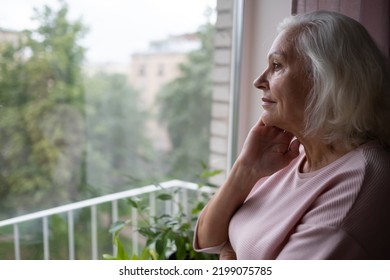 An Elderly Caucasian Woman Looks Sadly Out The Window.