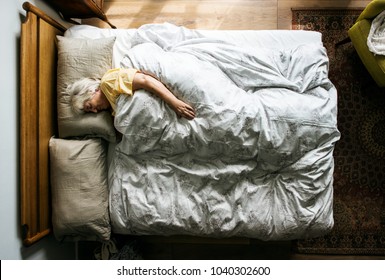 Elderly Caucasian Woman Sleeping On The Bed