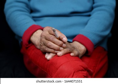 An elderly Chinese woman sitting and smoking- women empowerment concept - Powered by Shutterstock