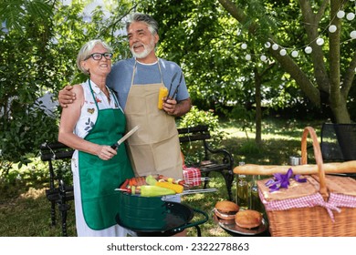 Elderly couple celebrate the 4th of July in their backyard. They are making barbeque, vegetables, and drinking beverages while enjoying and making memories - Powered by Shutterstock