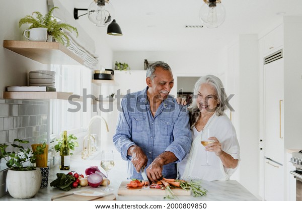 Elderly couple cooking in a\
kitchen