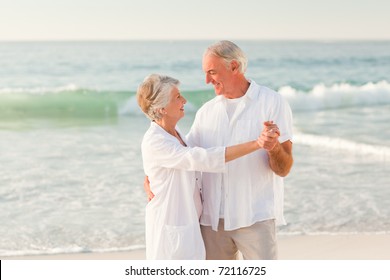 Elderly Couple Dancing On The Beach