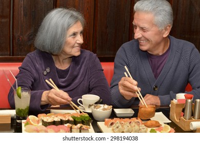 Elderly Couple Eating Sushi Together At Cafe