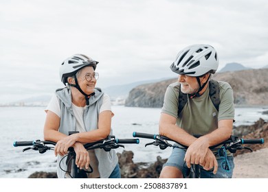 Elderly couple embracing in rocky beach outdoors having fun and enjoying together looking at the each other. Two old and mature people in love caring each other. - Powered by Shutterstock