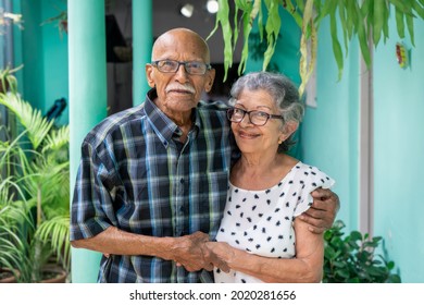 Elderly couple embracing and smiling looking at the camera