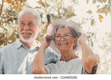 Elderly Couple Embracing In Spring Park Outdoors Having Fun And Enjoying Together Looking At The Trees. Two Old And Mature People In Love Caring Each Other.