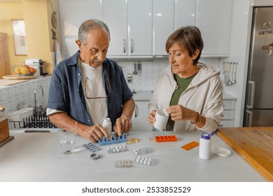 An elderly couple engages in a thoughtful discussion about medication management within a cozy kitchen setting, standing in casual clothing. Organizing pill box, daily routine at home. Horizontal - Powered by Shutterstock