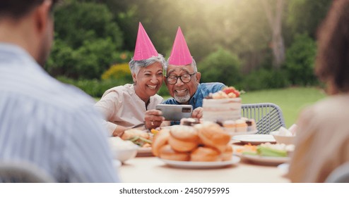 Elderly, couple and happy with video call at birthday party for celebration, laughing and memories in garden. Senior, man and woman with smartphone for photography, gathering and event in backyard - Powered by Shutterstock