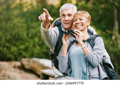 Elderly, couple hiking and bird watching with adventure outdoor, hike together and fitness for active lifestyle. Nature, trekking and senior man pointing and woman with binocular, freedom and travel