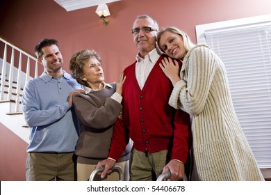 Elderly couple at home with adult children, senior man using walker