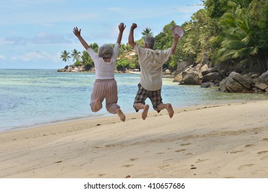 elderly couple jumping  at tropical beach - Powered by Shutterstock