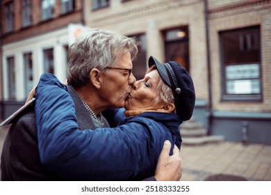 Elderly couple kissing outdoors on city street - Powered by Shutterstock