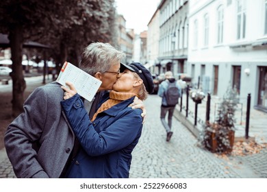 Elderly couple kissing outdoors on city street - Powered by Shutterstock