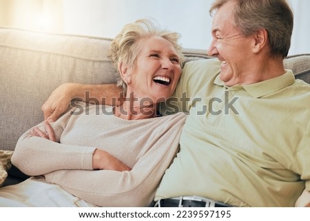 Elderly couple, laugh and hug on sofa in happy relationship, silly face or bonding together at home. Senior couple laughing, humor or relaxing while making funny goofy faces on living room couch