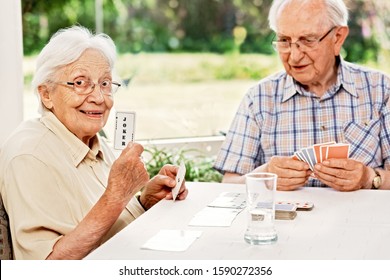 Elderly Couple In The Living Room, Playing Cards