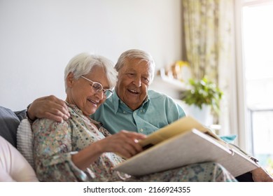 Elderly couple looking at a photo album while sitting on a sofa
 - Powered by Shutterstock