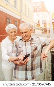 Elderly Couple Looking At The Route On The Map On Their Smartphone