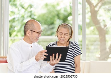 Elderly Couple Looking At A Tablet With A Smile