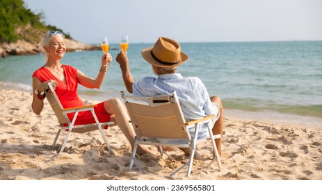 Elderly couple man and woman wearing fashion sunglasses talking together and looking at the sea sky sitting on chair on beach. Vacation trip summer holiday. - Powered by Shutterstock