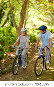 Elderly Couple Mountain Biking Outside