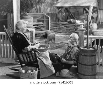 Elderly Couple On Porch Of Farmhouse