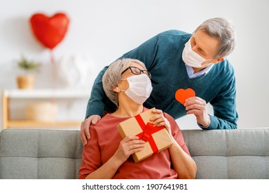 Elderly couple on valentine's day. Joyful nice senior woman and her husband are wearing facemasks.