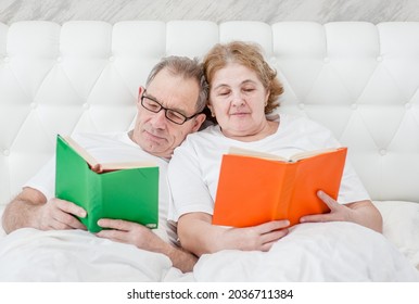 Elderly couple reading books on the bed before bedtime - Powered by Shutterstock