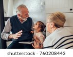 Elderly couple reading stories ti their granddaughter