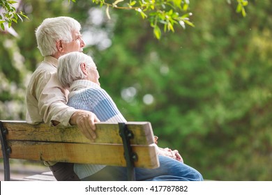 Elderly couple resting on a bench in the park - Shutterstock ID 417787882
